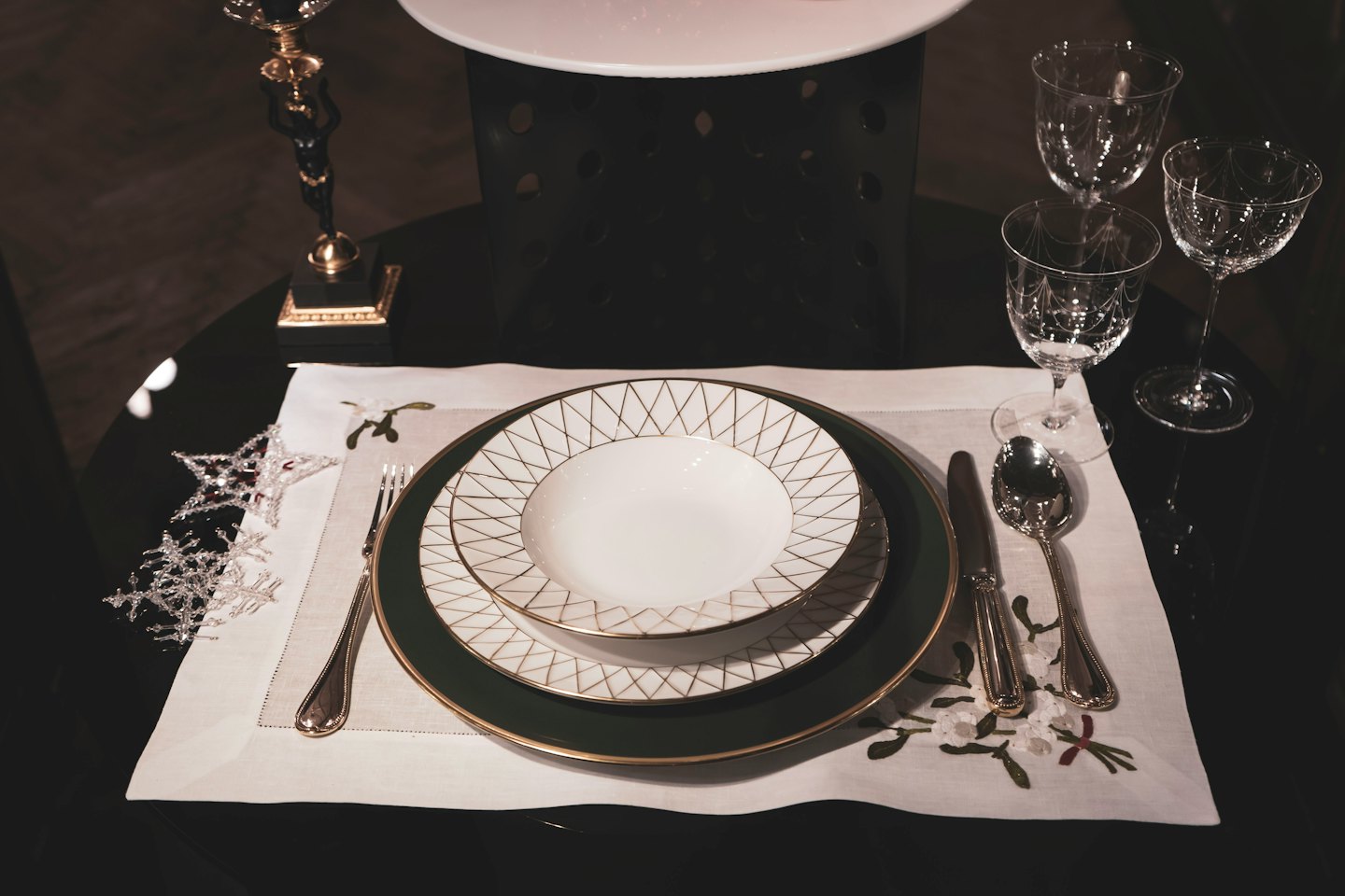 Table de salle à manger élégante dressée avec vaisselle, couverts et verres en cristal.