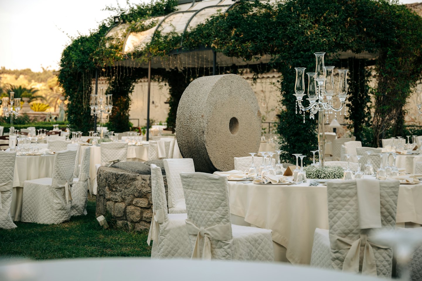 Tables de réception de mariage en plein air avec centres de table floraux et une roue à aubes.