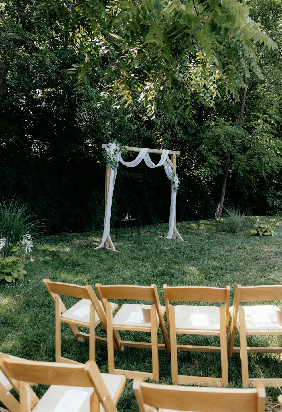 Arche en bois avec fleurs blanches installée pour un mariage en extérieur.