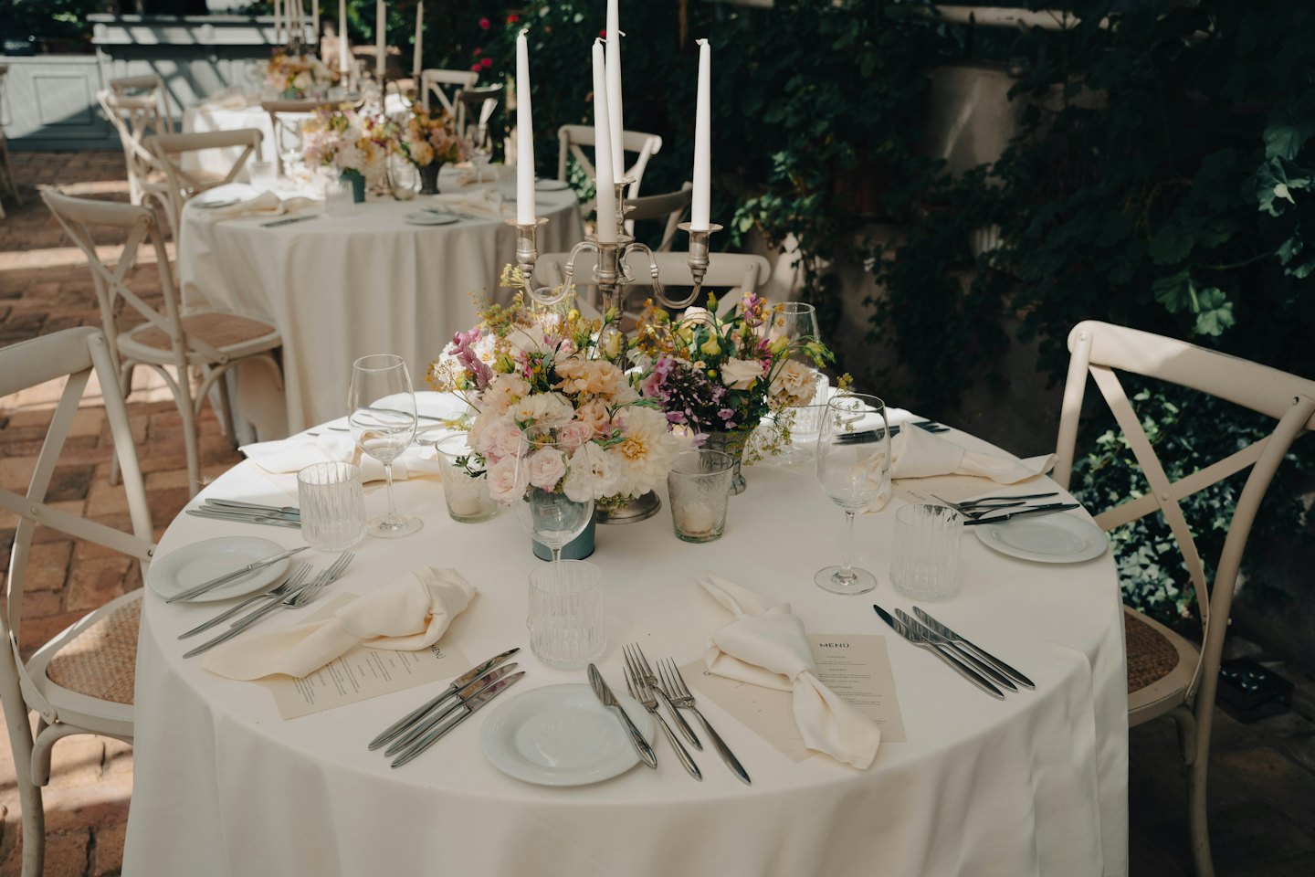 Élégante table de réception extérieure avec fleurs et candélabre.